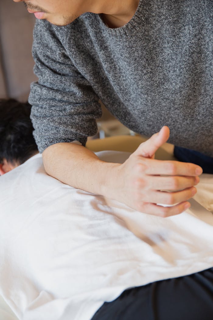 Massage therapist performing a therapeutic session, focusing on muscle relief and wellness.