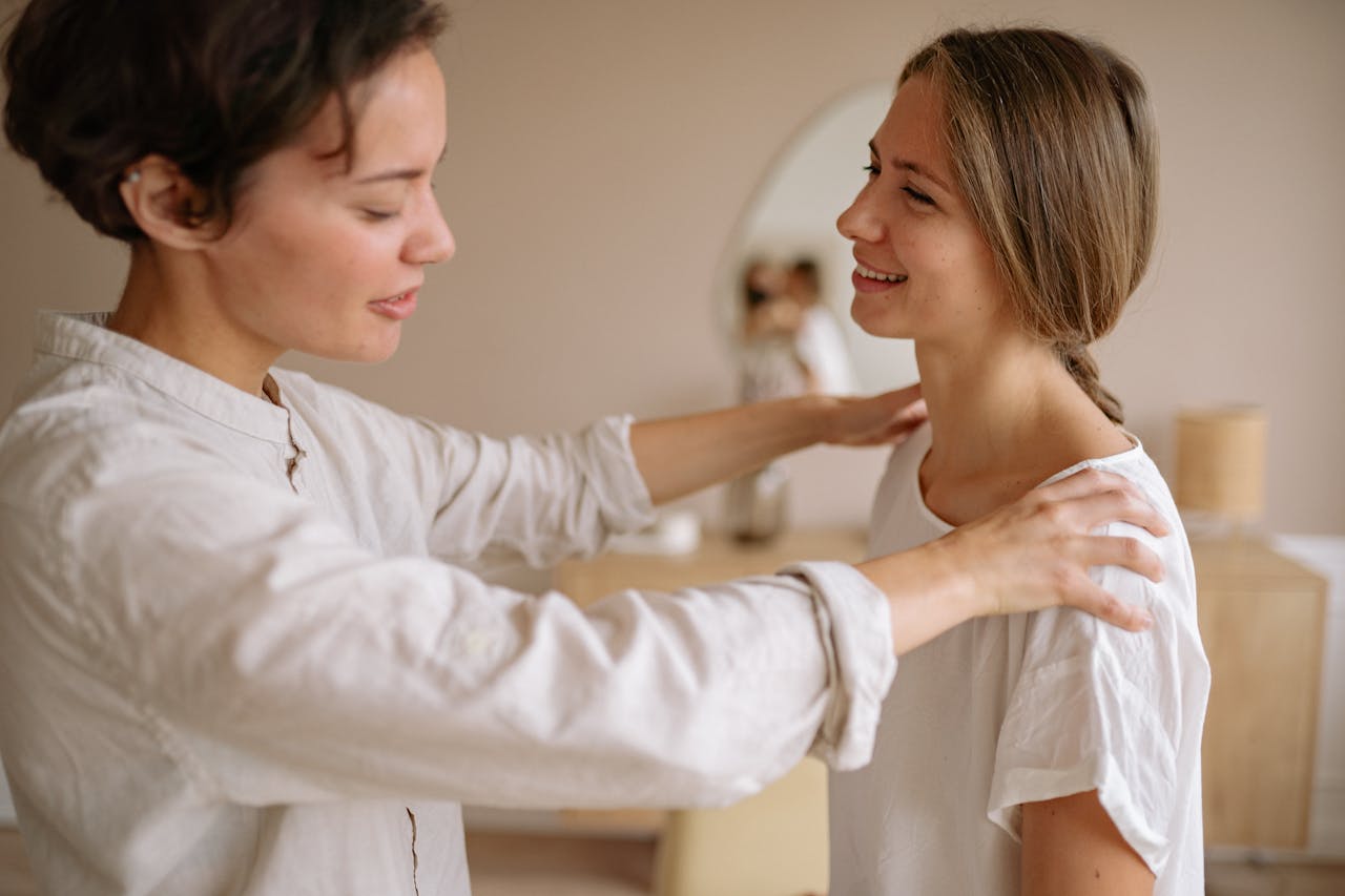 Two women engage in a calming massage therapy session in an indoor setting, promoting wellness.